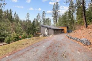 a house on a hill next to a dirt road at Beauty Bay Stunner in Coeur d'Alene