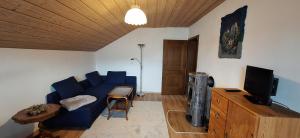 a living room with a blue couch and a television at Ferienhaus Resch in Laufen