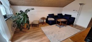 un salon avec un canapé bleu et une plante dans l'établissement Ferienhaus Resch, à Laufen
