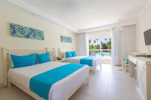 una camera d'albergo con due letti e una cucina di Vista Sol Punta Cana Beach Resort & Spa - All Inclusive a Punta Cana