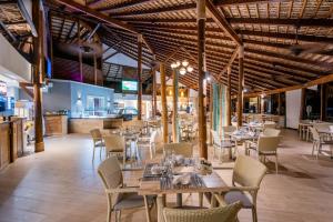 a restaurant with wooden ceilings and tables and chairs at Vista Sol Punta Cana Beach Resort & Spa - All Inclusive in Punta Cana