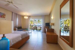 une chambre d'hôtel avec un lit et un salon dans l'établissement Vista Sol Punta Cana Beach Resort & Spa - All Inclusive, à Punta Cana