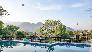 een zwembad in een resort met bergen op de achtergrond bij Mad Monkey Vang Vieng in Vang Vieng