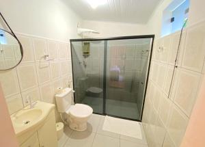 a bathroom with a shower and a toilet and a sink at Pousada Jardim Lençóis in Lençóis