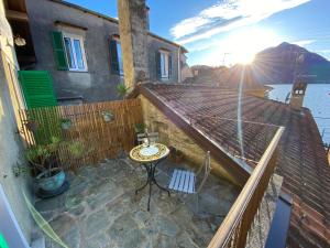 un patio con tavolo e sedie in cima a una casa di CHIAVE DI VOLTA Lovely Guesthouse with Terrace a Varenna