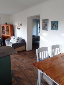 a living room with a table and a bed at Streams Cottage in Bettyʼs Bay