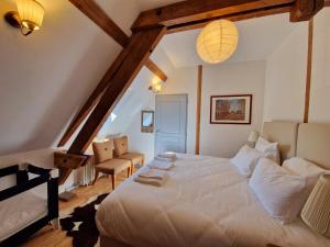 ein Schlafzimmer mit einem großen weißen Bett im Dachgeschoss in der Unterkunft HOTEL DE L'ABBAYE DE LONGPONT in Longpont