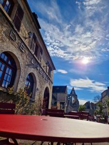 a red picnic table in front of a building at HOTEL DE L'ABBAYE DE LONGPONT in Longpont