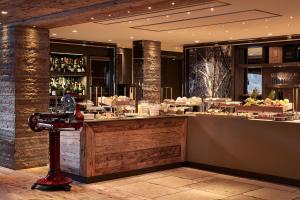 un ristorante con bar e cibo in esposizione di Rosapetra SPA Resort - Small Luxury Hotels of the World a Cortina dʼAmpezzo