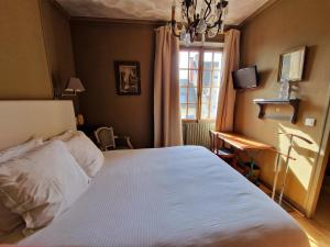 Tempat tidur dalam kamar di HOTEL DE L'ABBAYE DE LONGPONT