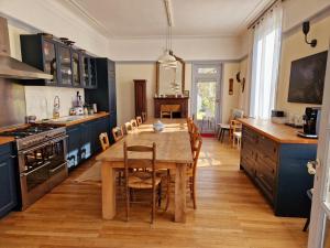 a kitchen with a wooden table and blue cabinets at HOTEL DE L'ABBAYE DE LONGPONT in Longpont