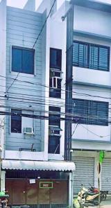 a tall building with windows and a balcony at Stargazing tent in Balcony at EKG House Rental in Manila