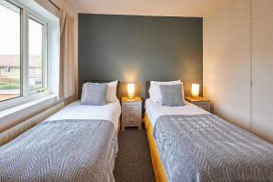 2 camas en una habitación pequeña con 2 lámparas en Host & Stay - Crab Cottage en Long Houghton