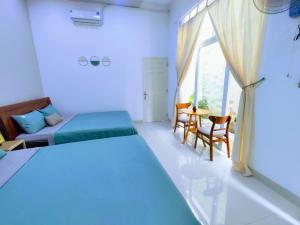 Schlafzimmer mit einem Bett, einem Tisch und Stühlen in der Unterkunft Nạp Homestay in Kinh Dinh