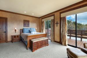 a bedroom with a bed and a balcony at Catamount Lodge in Ridgway
