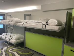 vier Etagenbetten in einem Zimmer mit grüner Tür in der Unterkunft Burghaus-Cochem in Cochem