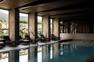 una casa con piscina, sedie e finestre di Rosapetra SPA Resort - Small Luxury Hotels of the World a Cortina dʼAmpezzo