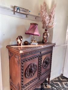 un viejo armario de madera con una lámpara encima. en The Yellow Mansion! Αγιος Γεώργιος Νηλείας Πήλιο, en Agios Georgios Nilias
