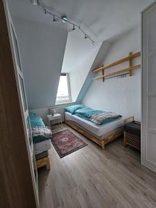 a attic bedroom with two beds and a window at Apartmenthaus Delitzsch 1-2 Zimmer Apartments in Delitzsch