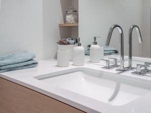 a bathroom sink with two faucets and two towels at Wohntraum direkt am See in Stansstad
