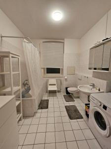 a white bathroom with a sink and a toilet at Apartmenthaus Delitzsch 1-2 Zimmer Apartments in Delitzsch
