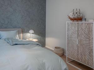 sypialnia z białym łóżkiem i stołem z lampką w obiekcie Wohntraum direkt am See w mieście Stansstad