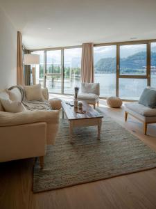 a living room with a couch and a coffee table at Wohntraum direkt am See in Stansstad