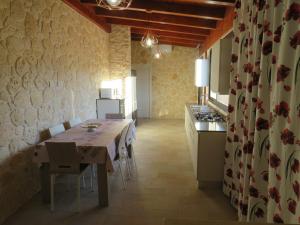 a dining room with a table and a kitchen at B&B Romano in Gela