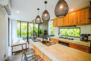 eine Küche mit Hängeleuchten und einem Aquarium in der Unterkunft Tiny Villa Nyanyi - 2 BR Architectural Villa 4 mins to Beach in Tanah Lot