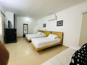 a bedroom with two beds and a tv in it at Hotel Platinum Boutique in Montería
