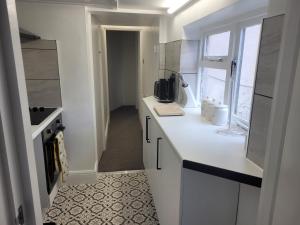 a white kitchen with a counter and a window at Beautiful 1-Bed Apartment in Ramsgate in Ramsgate