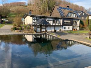 a house with a pool of water in front of it at Zur Clemens Hütte in Drolshagen