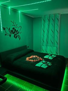 Un dormitorio con una cama con luces verdes. en Fabianna suite, en Agliano Terme