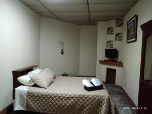Antigua Sweet Apartment في أنتيغوا غواتيمالا: غرفة نوم بها سرير وعليها هاتفين
