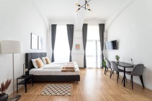 una camera da letto con un letto, un tavolo e delle sedie di Neat Studio Steps to Center by HM a Vienna