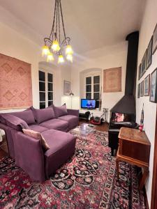 sala de estar con sofá púrpura y chimenea en The Yellow Mansion! Αγιος Γεώργιος Νηλείας Πήλιο, en Agios Georgios Nilias