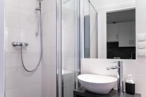un bagno bianco con lavandino e doccia di Neat Studio Steps to Center by HM a Vienna