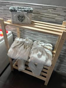 una estantería de madera con toallas y botas. en Fabianna suite, en Agliano Terme