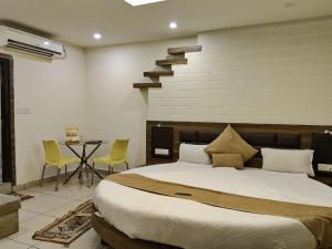 a bedroom with a large bed and a staircase at Abhilasha hotel pachmarhi` in Pachmarhī