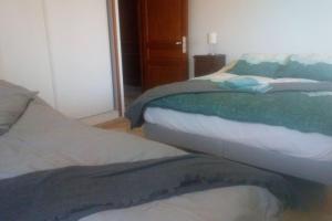 um quarto com 2 camas com lençóis verdes e brancos em Chambres d'Hôtes, Domaine Les Peupliers em Lagnes