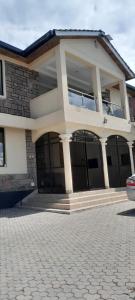 a large house with a driveway in front of it at Twiga Whitehouse Villas in Nakuru