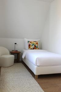 una camera bianca con un letto bianco e un tavolo di Boutique Wohnung mit Domblick a Paderborn