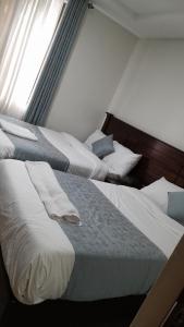 two beds sitting next to each other in a room at Twiga Whitehouse Villas in Nakuru