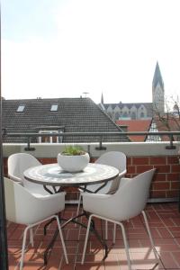 un tavolo bianco e sedie su un balcone di Boutique Wohnung mit Domblick a Paderborn