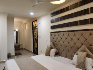 una camera da letto con un grande letto con una grande testiera di Abhilasha hotel pachmarhi` a Pachmarhī