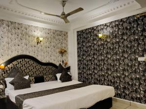 a bedroom with two beds and a black and white wallpaper at Abhilasha hotel pachmarhi` in Pachmarhī