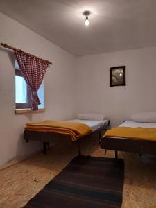 2 camas individuales en una habitación con ventana en Kuća za odmor Vučipolje, en Tomislavgrad