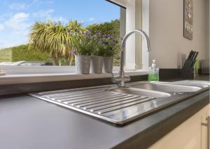 encimera de cocina con fregadero y ventana en Benone Getaways, en Derry Londonderry