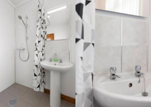 a white bathroom with a sink and a toilet and a tub at Benone Getaways in Derry Londonderry