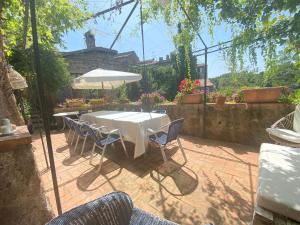una mesa con sillas y una sombrilla en el patio en Splendida villetta con giardino en Barbarano Romano